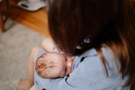 Mother breastfeeds a newborn at home on the couch. the benefits of breastfeeding