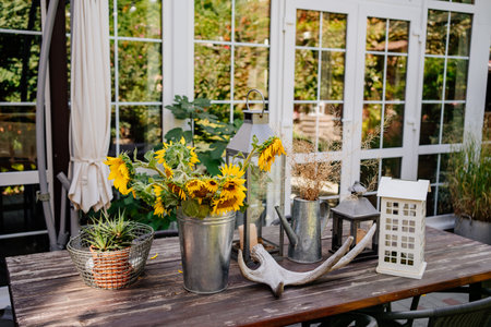 outdoor table decor in rustic style with sunflowers in a bucket and mini aloeの写真素材