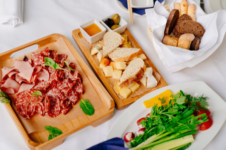 serving Board with light meat snacks, assorted cheeses and olives.