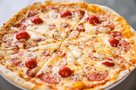 pepperoni pizza with cheese and tomatoes. ordering food at home.の写真素材