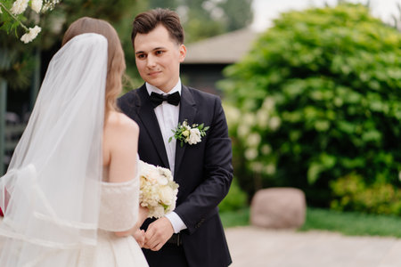 wedding ceremony in arch of living flowers. the groom listens to the brides vowの写真素材