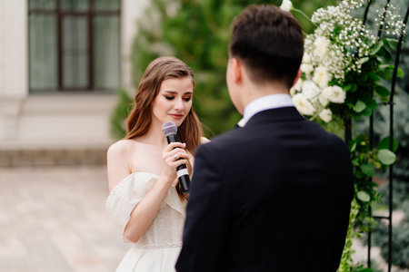 wedding ceremony in arch of living flowers. bride says wedding vow and cryの写真素材