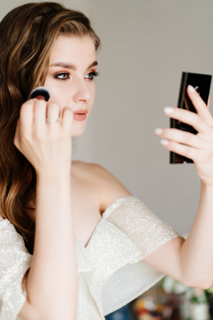 Beautiful young woman doing makeup. preparing the bride for the wedding.