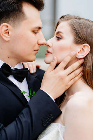 beautiful, gentle and happy bride and groom. man gently touches womans faceの写真素材