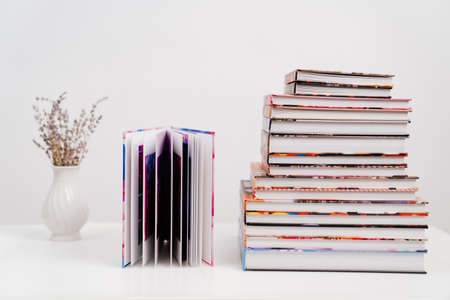 a stack of photobooks and an open photo album. the printed products.の写真素材