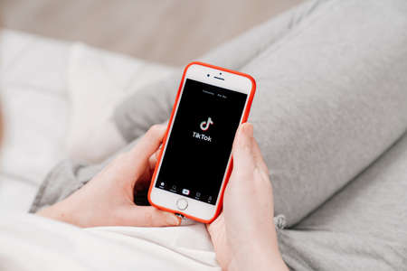 tiktok. iPhone in hand. installing app on a smartphone.のeditorial素材