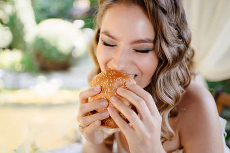 The bride have fun and eat hamburgers. snack for newlyweds.の写真素材