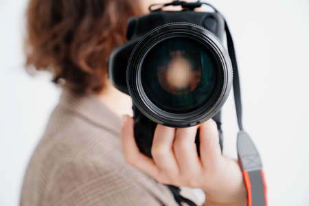 professional SLR camera in womens hands. fascination with photography