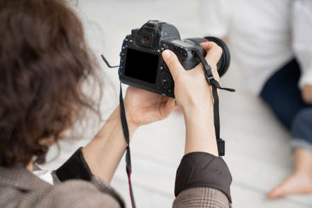 A brunette woman working photographer. photo shoot in a photo studio. backstageの写真素材