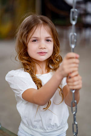 close up. pretty girl in white clothes rides on swing. childrens dreams.の写真素材