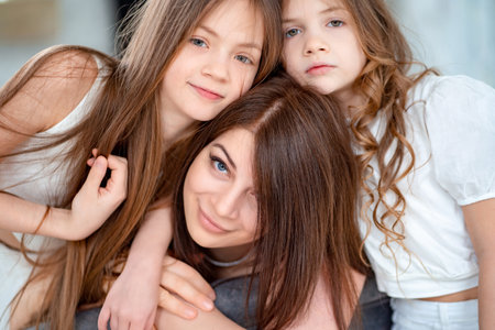 Mom cuddles with her daughters. happy family. unconditional love.の写真素材