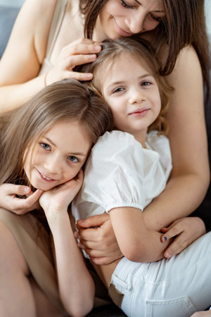 Mom cuddles with her daughters. happy family.の写真素材