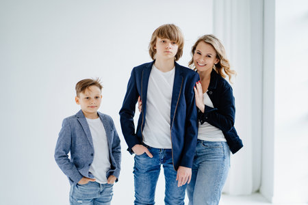 A mother with two sons in blue clothes have fun and poses for a photo shootの写真素材
