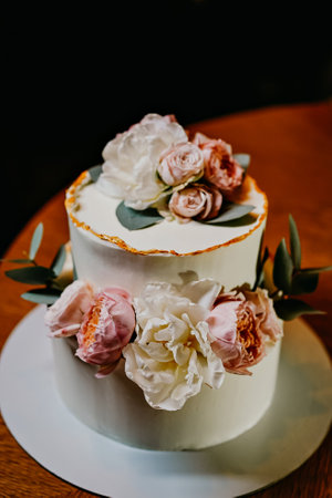 white cake decorated with live flowers. Traditional wedding cake.