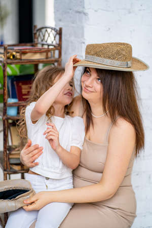 Mom with her daughter have fun and fit on hats. happy family.の写真素材