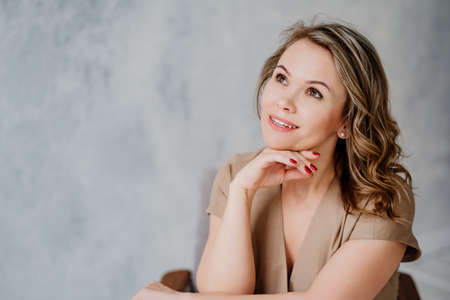 A blonde woman in a beige dress. cosmetics and beauty salonsの写真素材