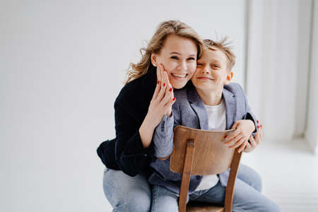 A mother with son in blue clothes having fun and poses for a photo shootの写真素材