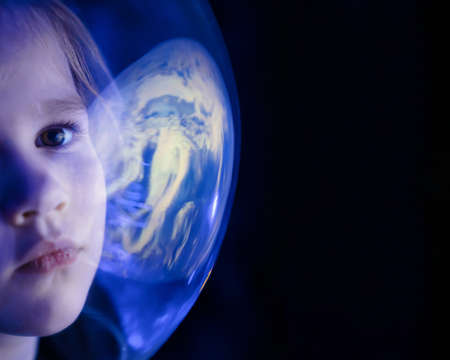 girl dreams of becoming astronaut and flying into space. reflection of planetの写真素材