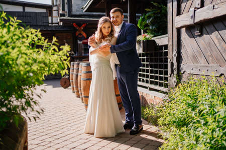 The bride and groom cuddle standing in the retro courtyard of the restaurantの写真素材
