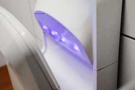 close up. hand dryer in a public toilet. hygiene and hand washingの写真素材
