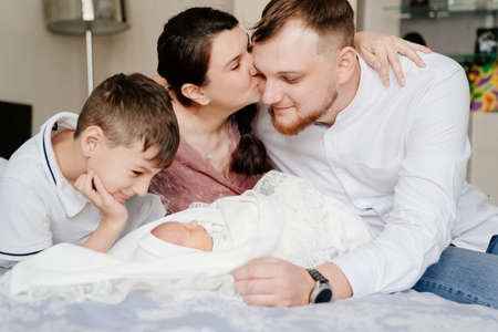 the first day of the newborn at home. Happy family with a toddler in the bedroomの写真素材