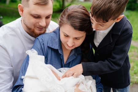 family with a baby in their arms in the park. discharge from the hospital.の写真素材