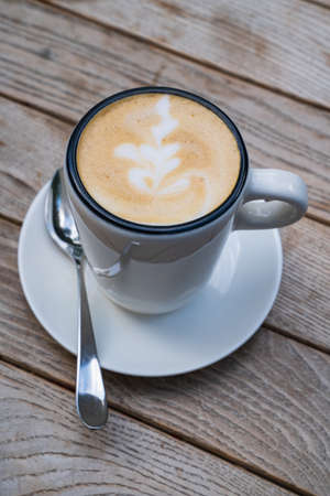 cup with a cappuccino on a wooden table. Delicious coffeeの写真素材