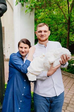 A mother and father with a newborn baby stands at the exits of the hospital.の写真素材