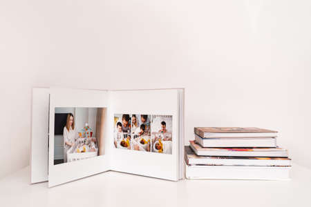 on white table open photobook from photo shoot of family with newborn.の写真素材