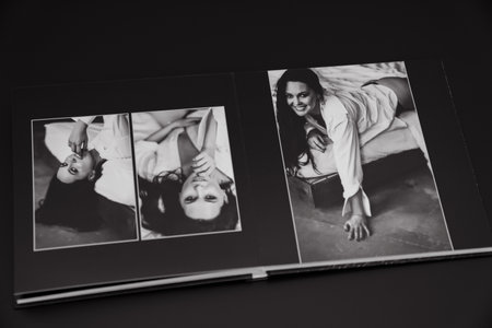 open photobook from a photo shoot of an attractive woman on a black background.の写真素材