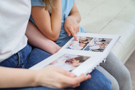 top view. mother and daughter watch photobook from discharge of newborn baby