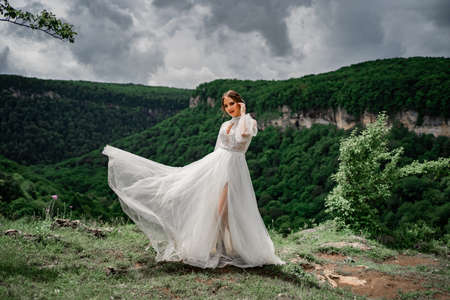 wedding photo shoot in the mountains. the bride in flutters skirt on the meadow.の写真素材