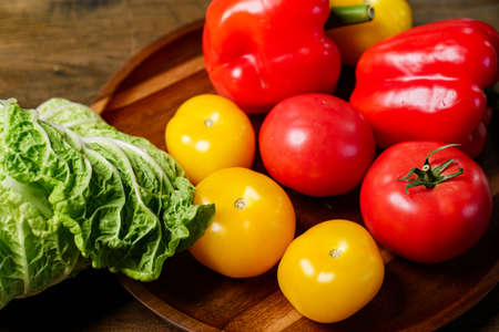 lettuce, yellow and red tomatoes and bell pepper with water drops. cucumbers.