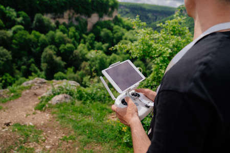 a man holds remote control from a drone in his hands and shoots a video.