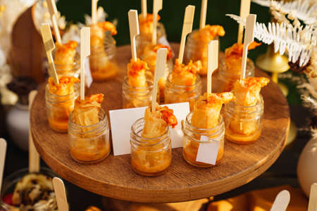 serving shrimp with sauce in portions in small glass jars. buffet for holiday.