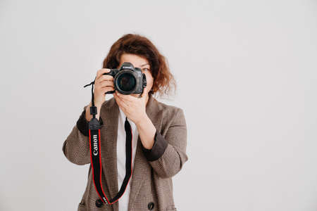 brunette woman on a white background takes pictures, works with the modelのeditorial素材