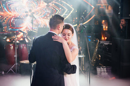 the bride and groom dance on stage in the banquet hall of the restaurant.の写真素材