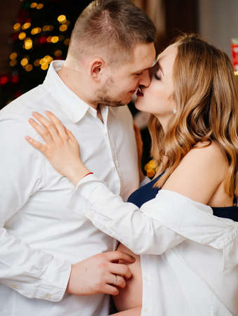 a beautiful pregnant woman and a man in white shirts in the New Years kitchen.の写真素材