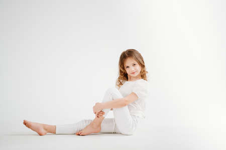 barefoot little girl with long hair in white clothes.shampoo for childrens hair