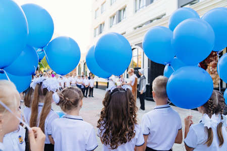children with blue balloons on the first school day at school.のeditorial素材