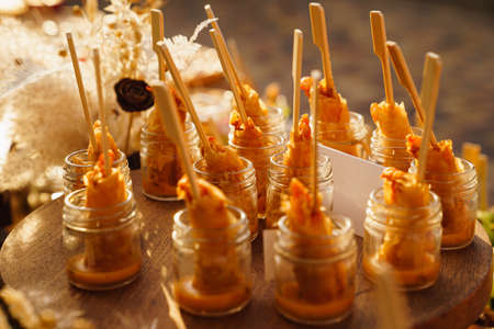 serving shrimp with sauce in portions in small glass jars. buffet for holiday.の写真素材