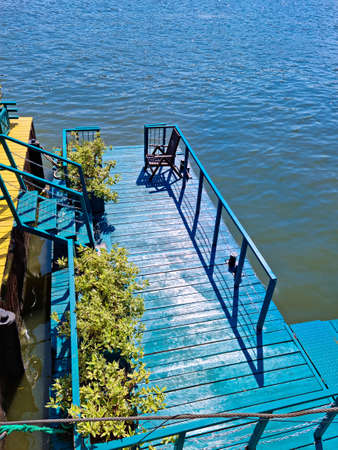 blue wooden pier on the river. water landscape. travel and boat trips.の写真素材