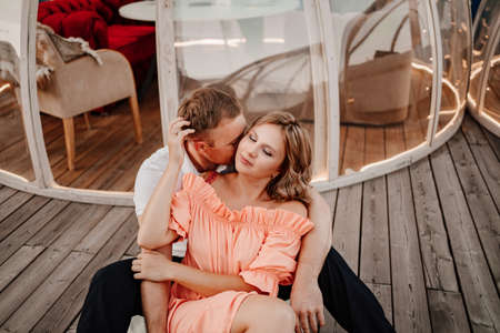 the woman rests on the mans shoulder sitting on the floor in a cafeの写真素材
