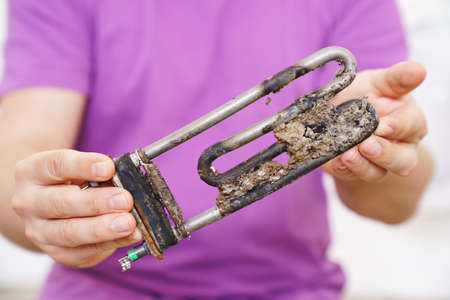 repair of washing machine. in hand old tubular electric heaterの写真素材
