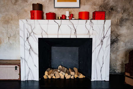 decorative marble fireplace with firewood in the interior.の写真素材
