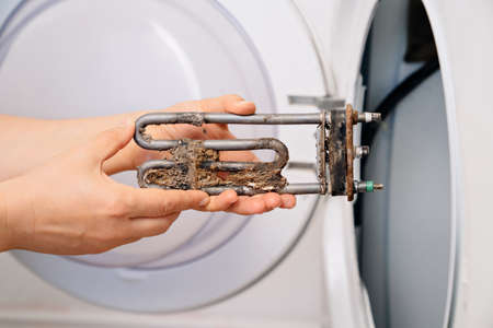repair of washing machine. in hand old tubular electric heaterの写真素材