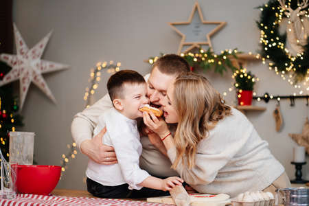 happy family prepares traditional dishes from dough for new year and eat cakesの写真素材