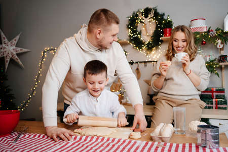 happy family prepares traditional dishes from dough for new year.mom is pregnantの写真素材