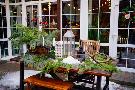 table decorated for new year with coniferous branches, lanterns and candles.の写真素材