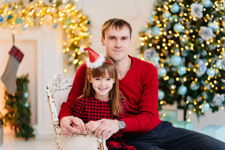 dad and daughter at the Christmas tree. happy family winter holidays.の写真素材